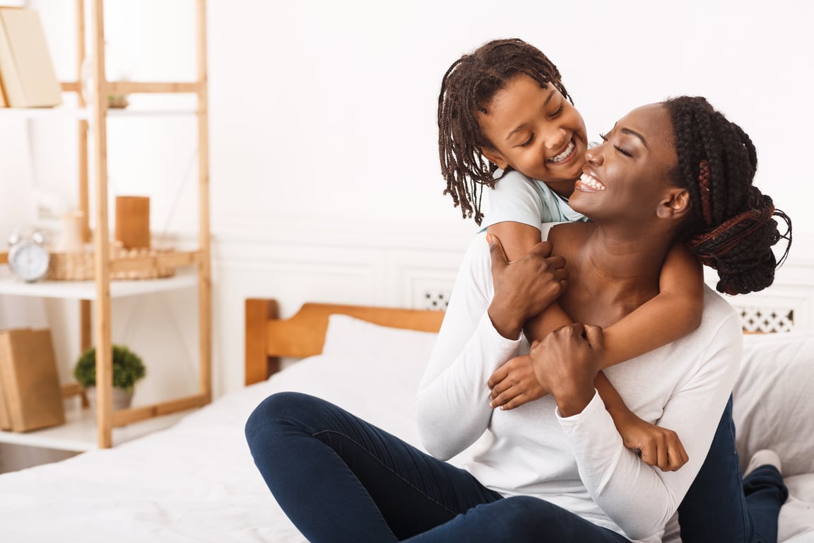 Black girl embracing her mom at home